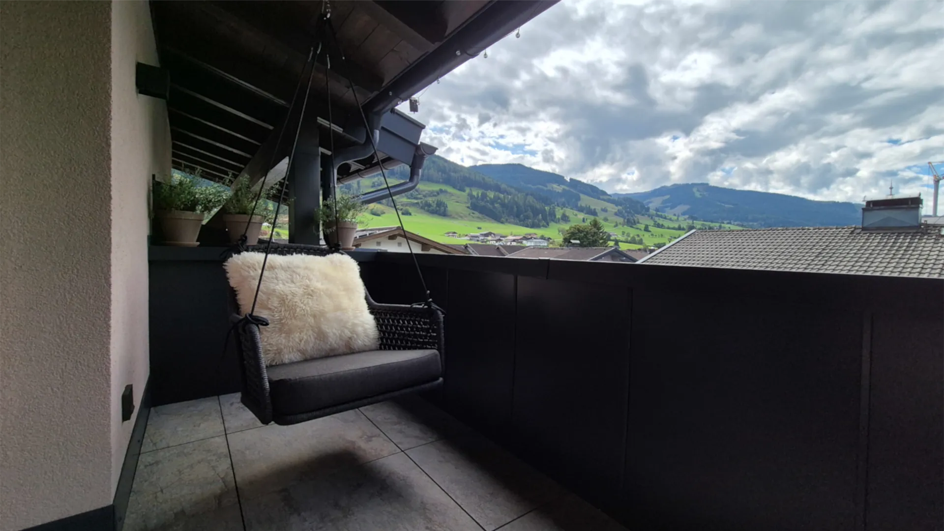 Private Dachterrasse mit Hängesessel und Blick auf die Berge