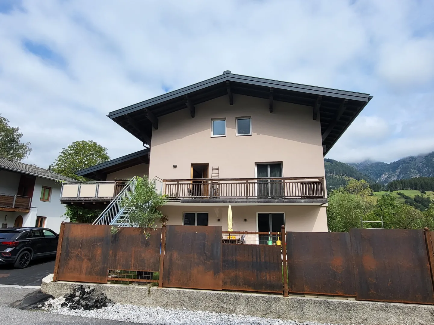 Das Wohnhaus von der Straße aus, mit Balkon und den Bergen rund um Leogang im Hintergrund